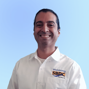 Picture of Nicholas Giraldo in a white shirt that says "Wyoming SBDC Network"