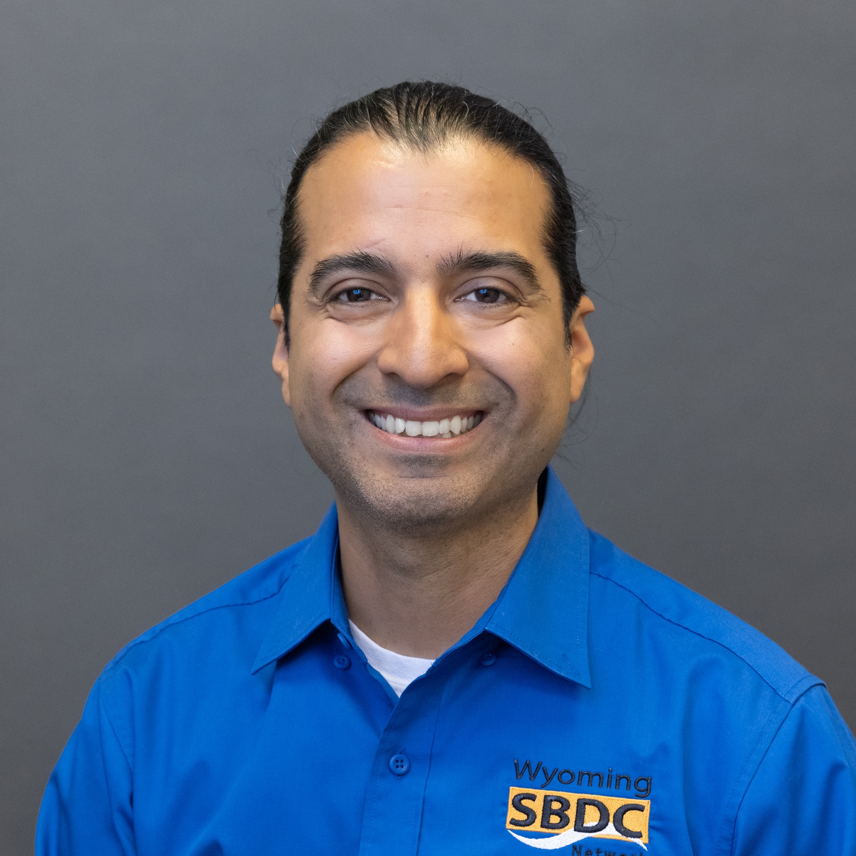 Picture of Nicholas Giraldo in a white shirt that says "Wyoming SBDC Network"